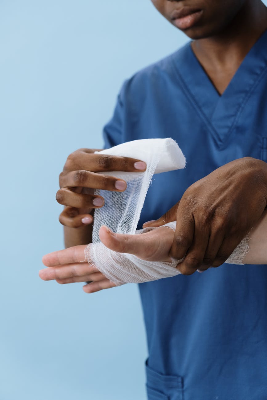 person in blue scrub suit holding white textile